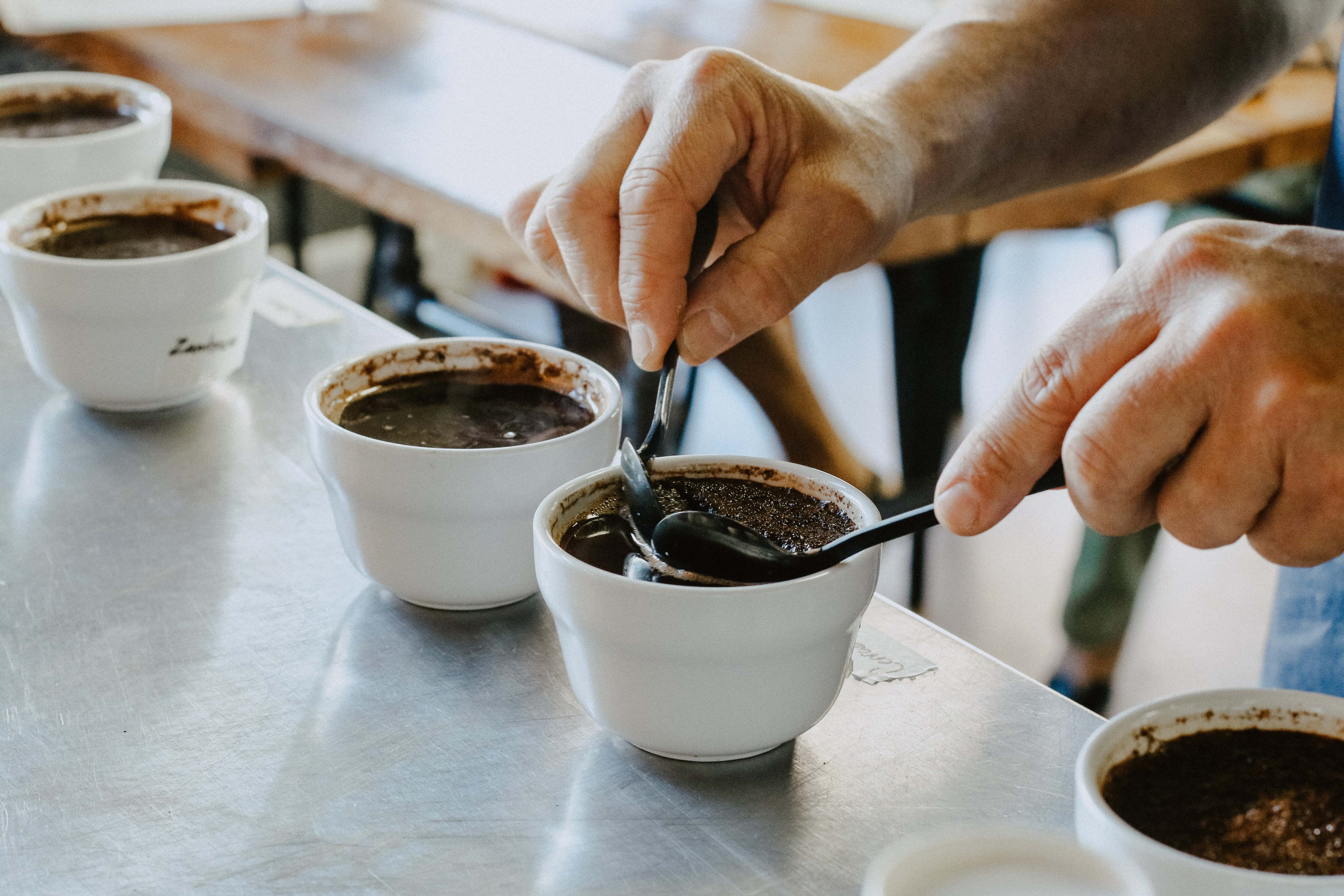 Person Stirring Coffee with a Spoon